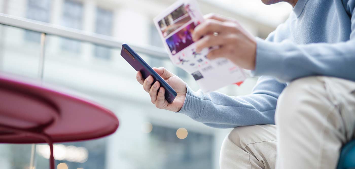 man reading direct mail and using phone